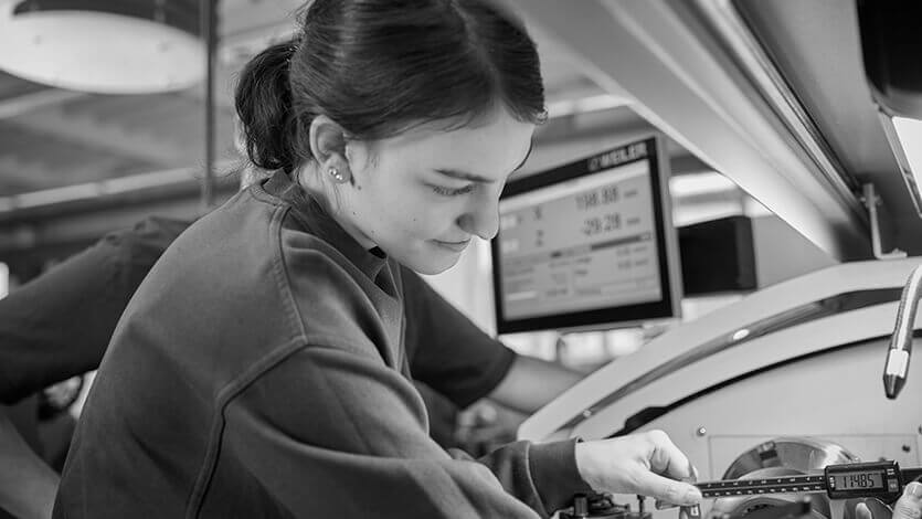 weibliche Auszubildende arbeitet an Maschine Schwarz und Weiß